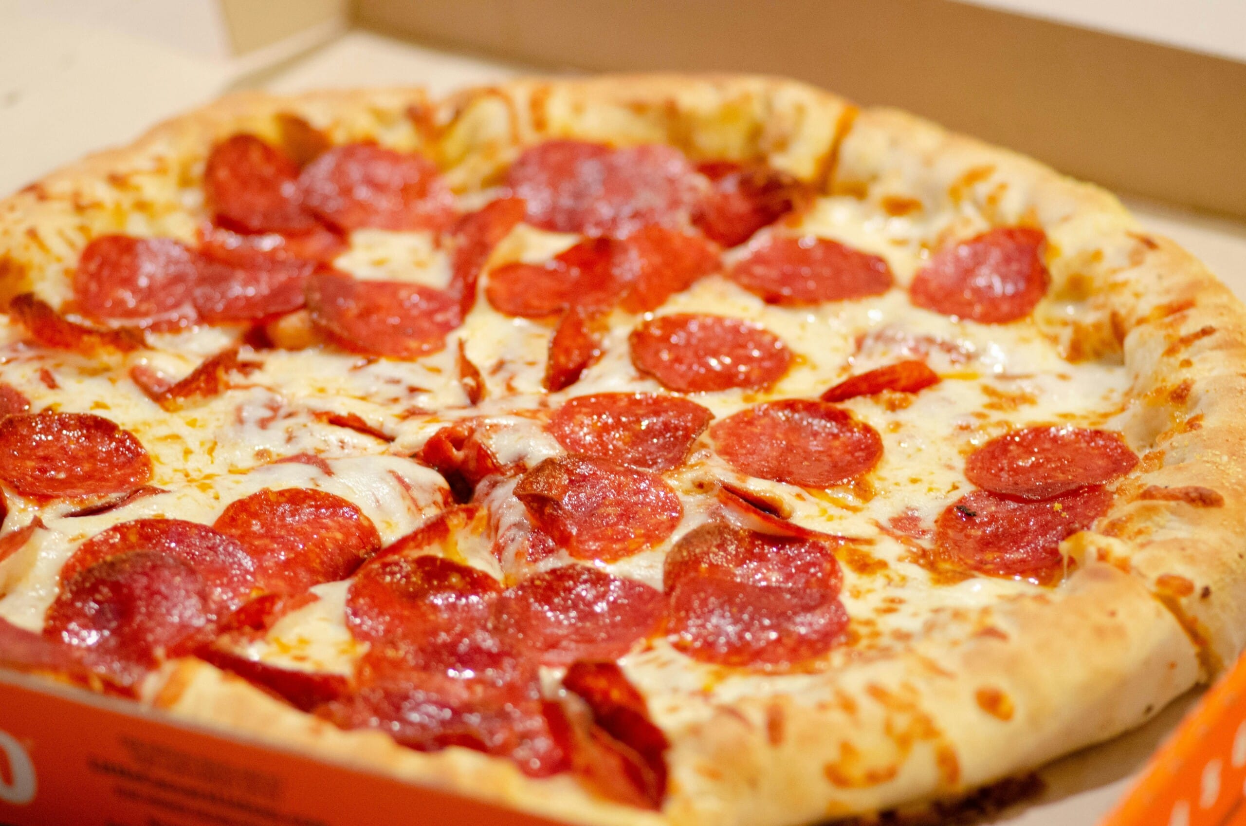 Pepperoni pizza with melted cheese in an open box