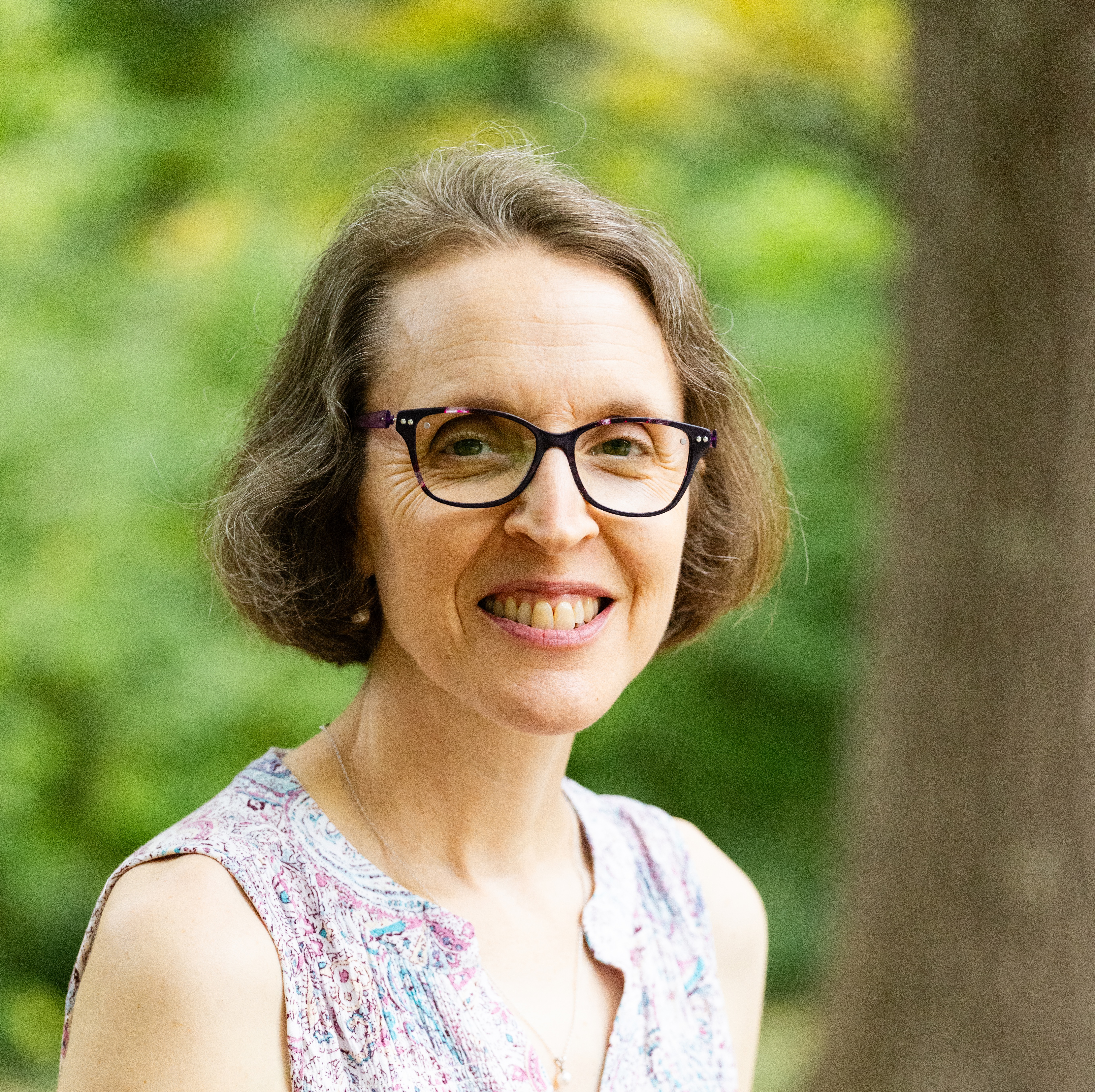 PIcture of woman outside smiling at camera with glasses