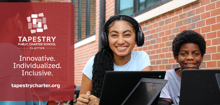 Students using laptops outdoors at Tapestry Public Charter School Clayton, smiling and engaged in learning in front of a brick school building.