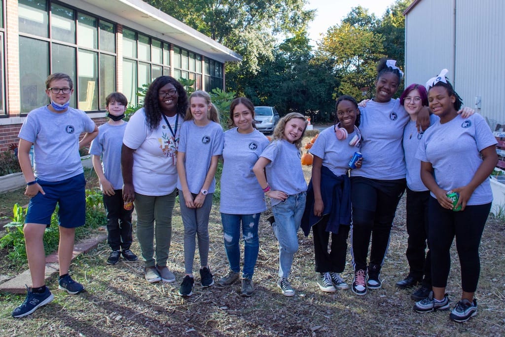 Group of diverse students in matching gray t-shirts outdoors